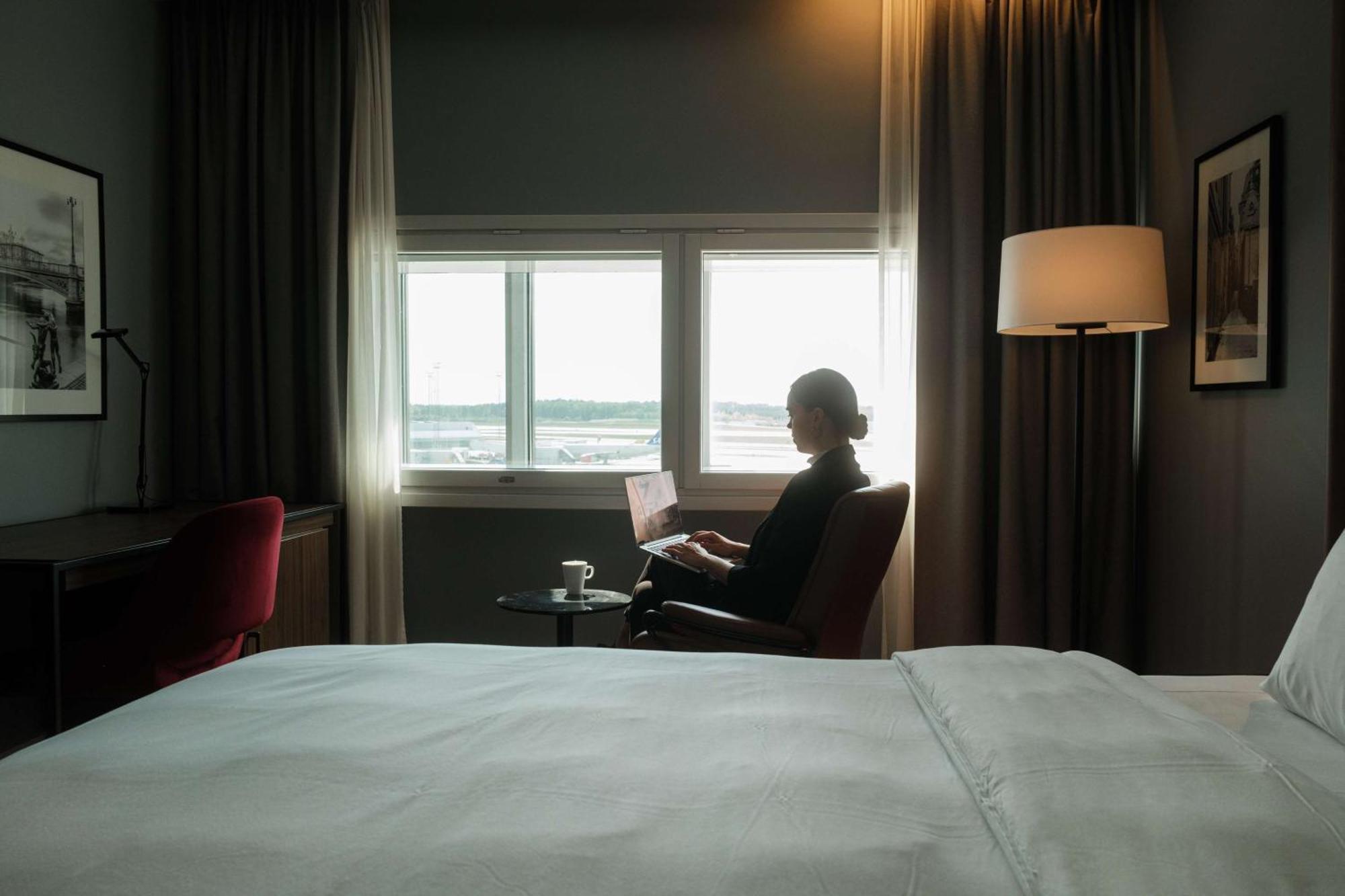 Radisson Blu Airport Terminal Hotel Arlanda Exterior photo A woman working from home with a view of the airport